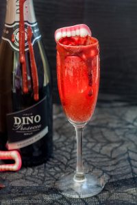 The Bloody Bellini, delicious blood is combined with bubbly prosecco to make the perfect Halloween Cocktail for Vampires, and those suffering with anaemia. If you're not a vampire, you can make this gruesome looking cocktail with Raspberry Puree and Raspberry Chocolate Syrup! Perfect to serve this halloween, and totally delicious too! #halloween #cocktail #bellini