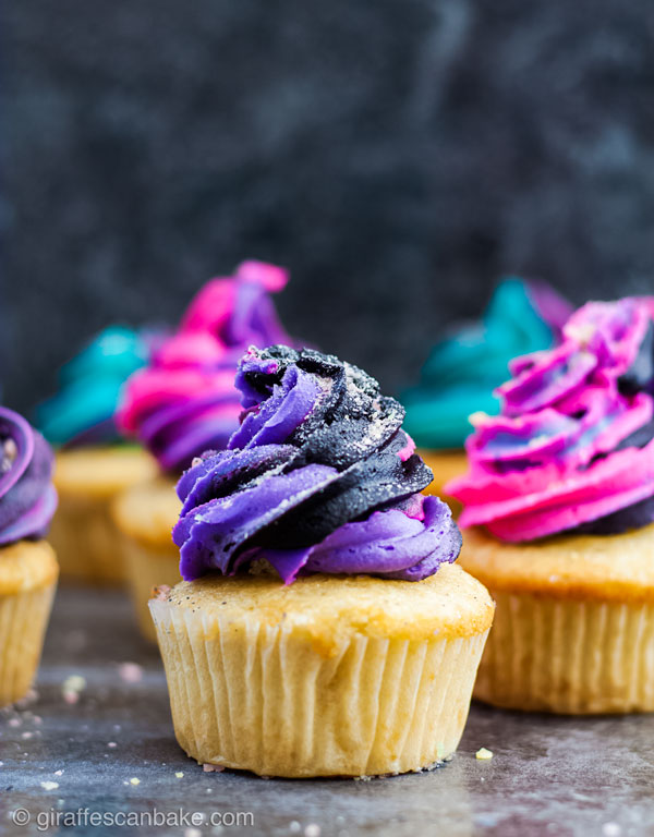 Fireworks Cupcakes - a gluten free vanilla cupcake with black buttercream swirled with neon buttercream, multiple fireworks cupcakes in background